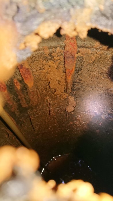 Inuti en varmvattenberedare med korrosion och kalkavlagringar.