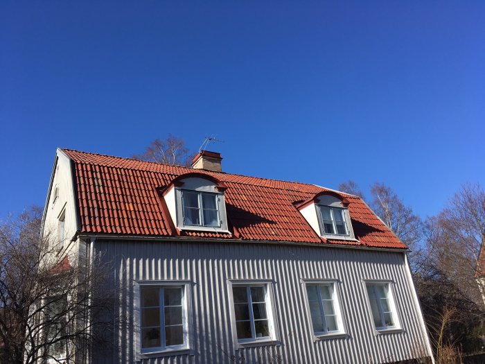 Renoverat hus med Vittinge lertegeltak, ny större taklucka och ny målning på takkupor och skorsten.