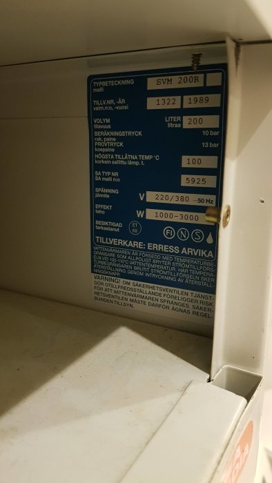 Typskylt på en äldre vit varmvattenberedare med tekniska specifikationer, märkt ERRESS ARVIKA.