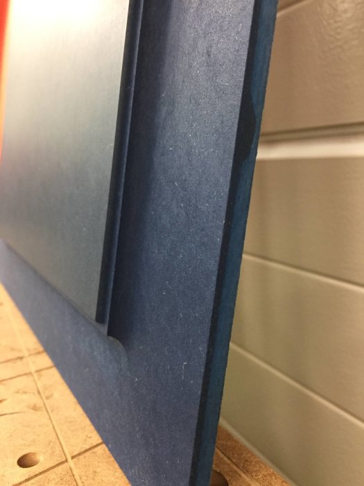 Blå isoleringsplatta lutad mot vägg, delvis bild med närbild på kanten.