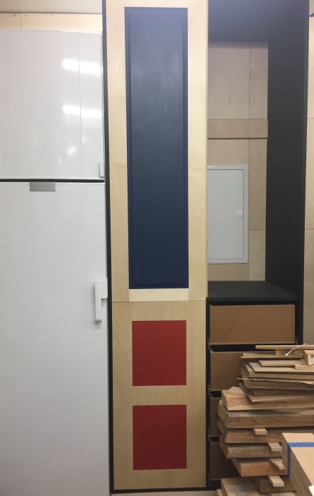 Träpanel monterad på vägg, behandlad med Danish Oil, med blå och röda rektangulära fält.