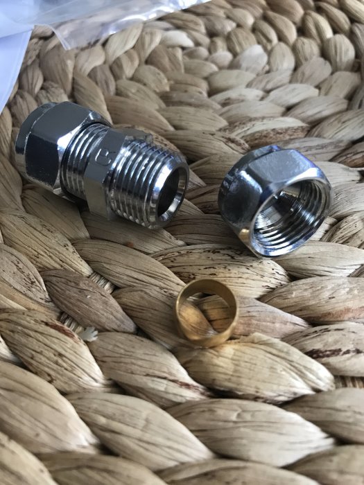 Metallmuttrar och klämring på ett flätat underlag, avsedda för VVS-installation.