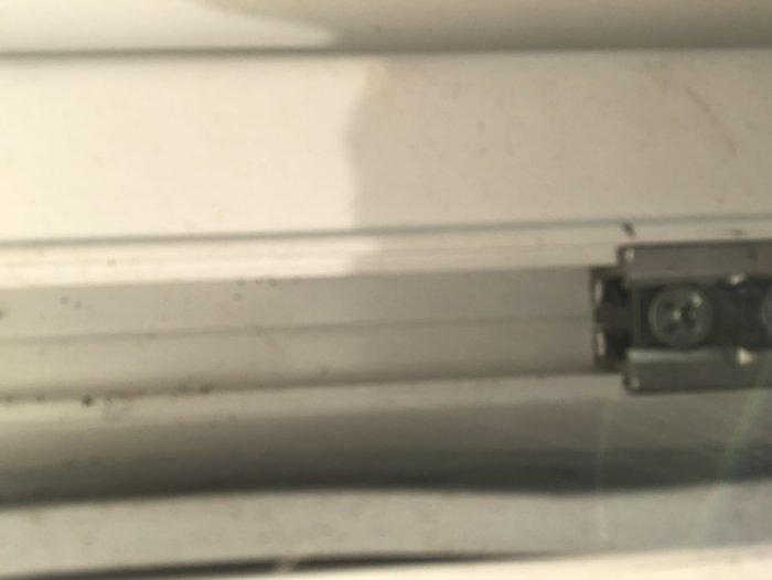 Undersida av balkongdörr med dörrlås sett inifrån en lägenhet.