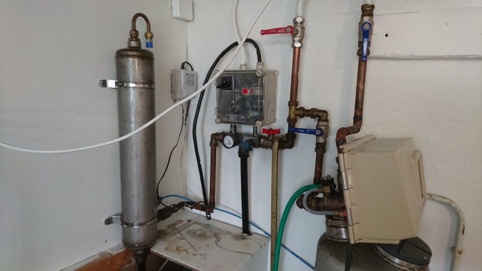 Vattenfilter installation med syreaktivator, mätare och kaliumpermanganat-injektor mot en vägg.