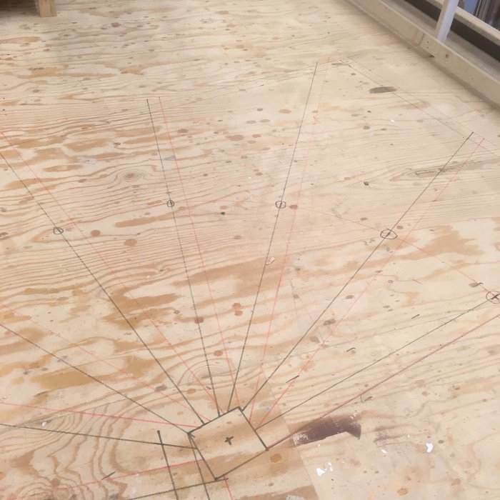 En fullskalig mall för en svängd trappa ritad med tusch på trägolv.