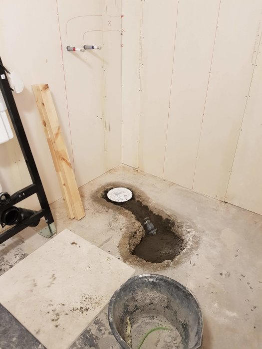 Installation av golvbrunn i betongplatta med synliga rörsystem och uppmärkta väggar före gjutning.