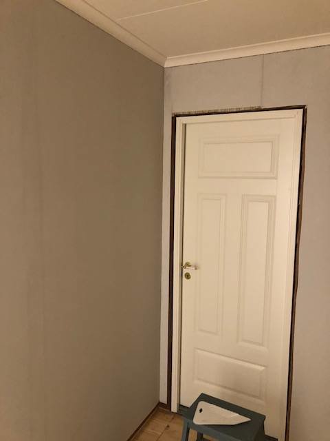Nyinstallerad renoveringstapet i en hall med en vit dörr och synliga skarvar före spackling.