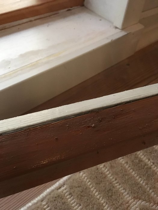 Träfönsterbågar med vit lack som sväller och klumpar sig vid påstrykning.