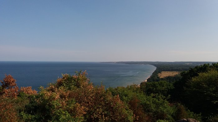 Utsikt från Stenshuvud över en klar himmel ovanför kustlinjen i Skåne, med Blekinge i horisonten.