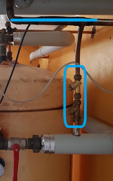 Två påfyllningsventiler på rör, övre och undre, ringade i blått, den övre visuellt äldre.