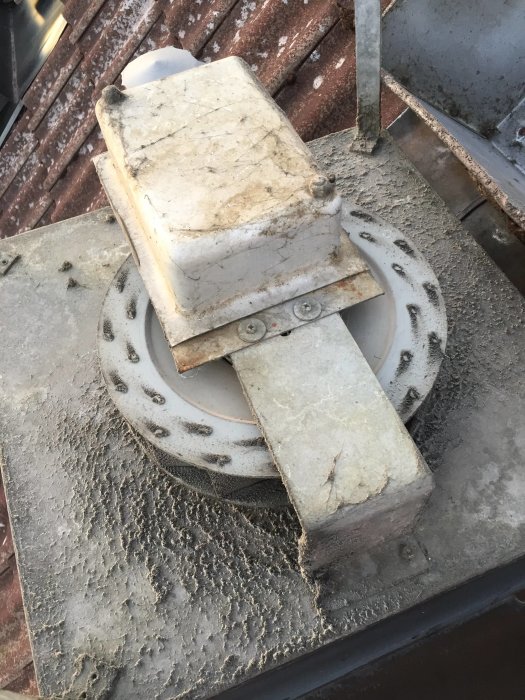 Gammal takfläkt på ett 70-talshus täckt av damm och möjlig korrosion, i behov av utbyte.