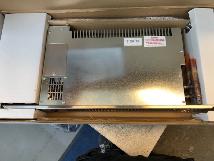 Ny vattenburen liggande radiator i förpackning inför installation i badrum.