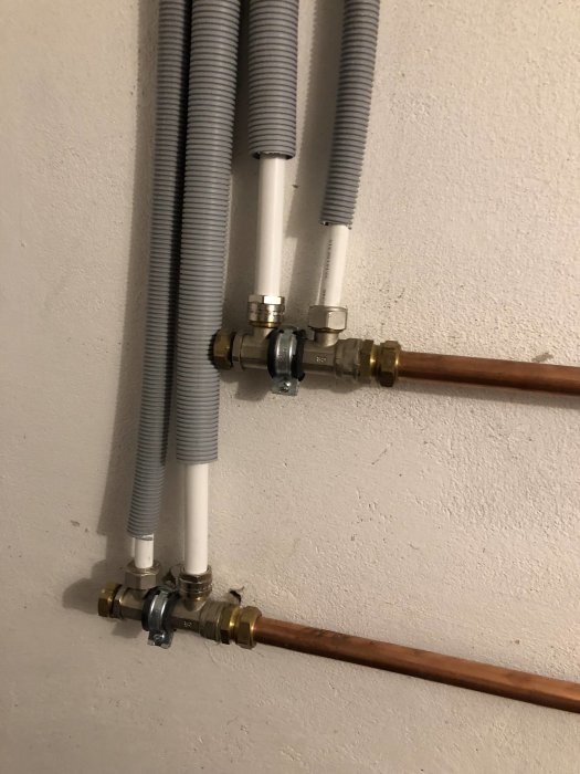 Installation av alu-PEX rör och kopplingar för vattenburen radiator på vägg.