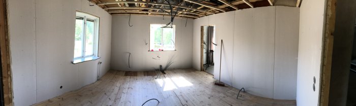 Renoverat rum med nyinstallerat gips samt synliga avlopps- och vattenrör i väggarna.