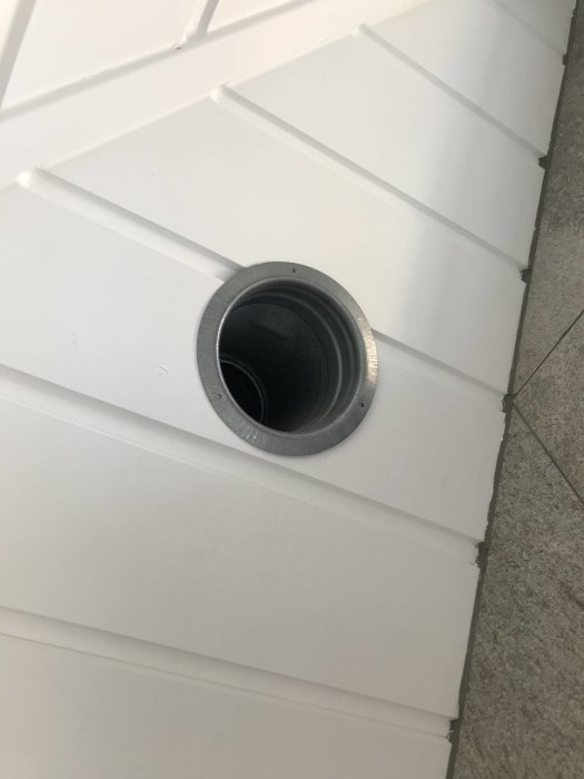 Rör genom vägg utan fästram, synliga skarvar på vit yta.