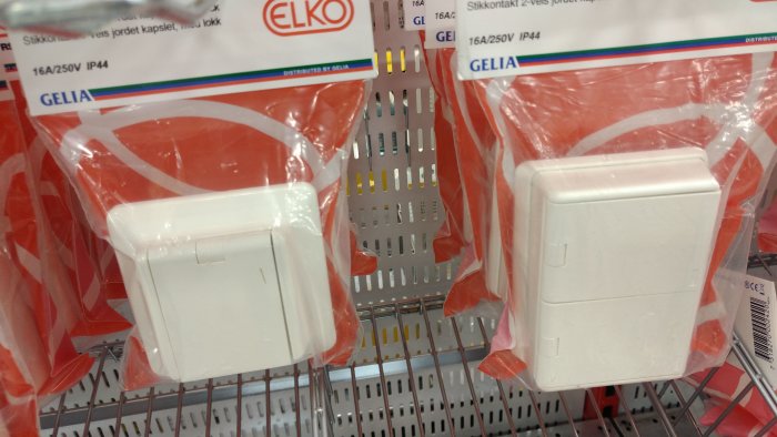 Eluttag med lock för säkerhetsfunktion, paketerade och upphängda i butikshylla.