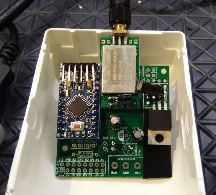 Elektronikmodul med Nrf24l01+ förstärkare, extern spänningsregulator och plats för Atsha204, i en vit låda.