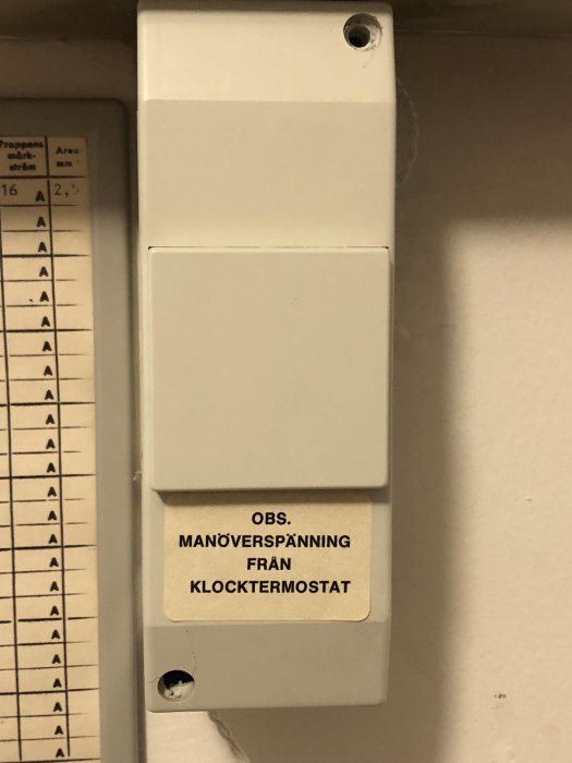 Termostat med varningsetikett "OBS. MANÖVERSPÄNNING FRÅN KLOCKTERMOSTAT" och installationsdiagram.