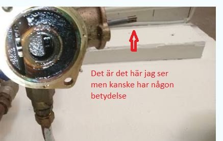 Delvis öppen värmeledningskoppling med synlig mineralavlagring och text som pekar på en detalj.