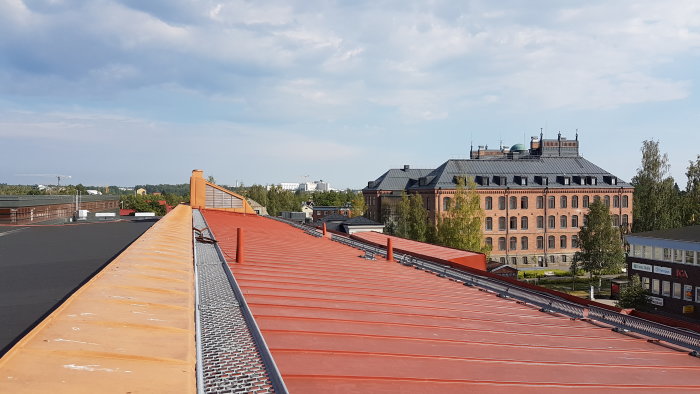 Utsikt över ett rött tak och historisk byggnad från ett byggprojekt i kallt väder.