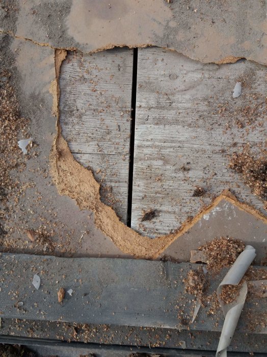 Närbild av plywoodskarv med masonitskiva och ojämnt spridna spån.