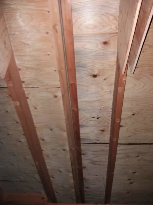 Takstolar med plywood och masonitskarv, synliga strö och dubbla träbär.