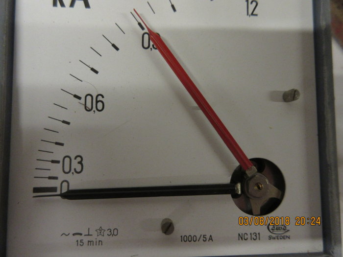 Analog amperemeter med röd visare, skalfaktorer och datumstämpel, ej i bruk.