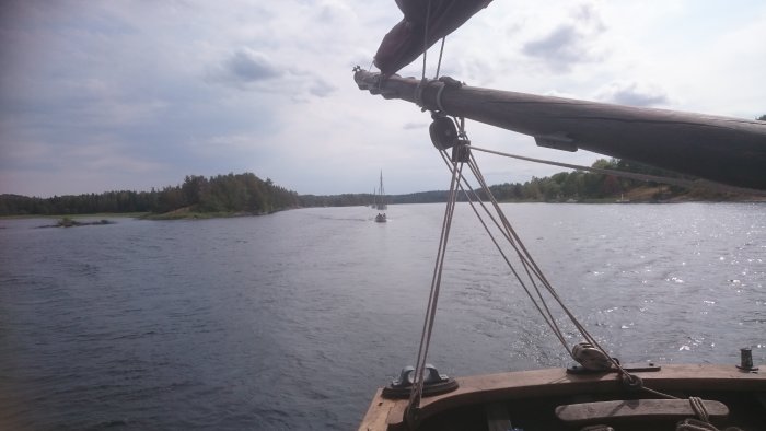Vy från skuts däck på en båtparad i Dalslands kanal under solig dag.