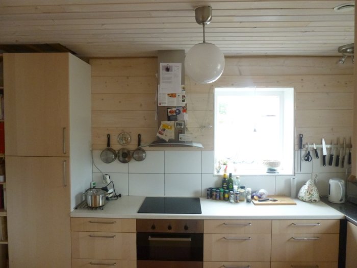 Vitkaklat kök med trädetaljer, vit arbetsbänk, fönster och inredning från 2011.