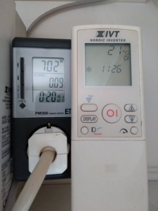 Energimätare visar 702 watt och avfuktarens kontrollpanel anger 21 grader Celsius, taget kl 1:26.