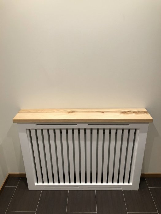 DIY MDF radiator cover with a handmade glued ash wood top in a modern home setting.