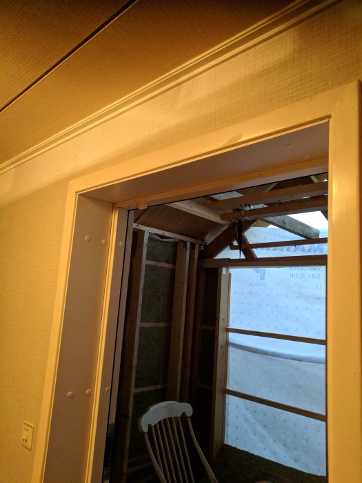 Pågående bygge där balkong omvandlas till rum, med synliga reglar och isolering.