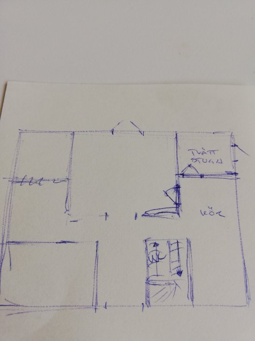 Snabb skiss av husplanlösning med centralt placerad matsal, kök, trappa och utrymme för gäst-wc eller garderob.