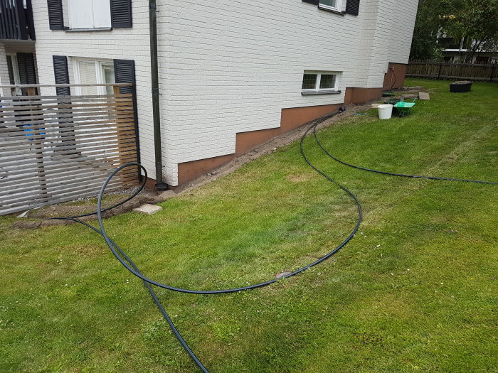 Irrigation hose laid out on a lawn for a sprinkler system installation process.