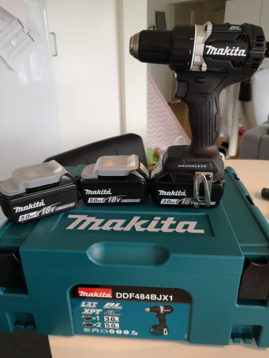 Makita borrskruvdragare med extra batterier på en grön verktygslåda.