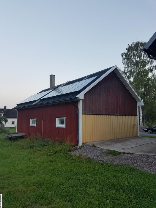 Röd och gul garagebyggnad med möjlig placering för snetak/skärmtak på baksidan.
