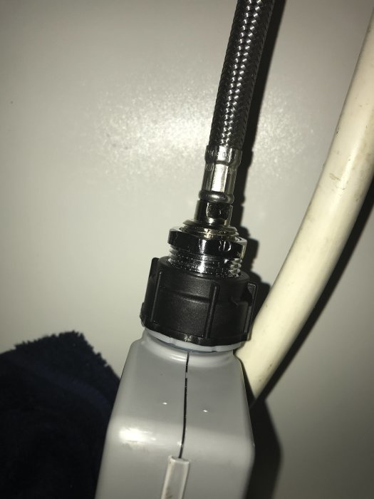 Koppling mellan diskmaskinslang och vattenkran som läcker.