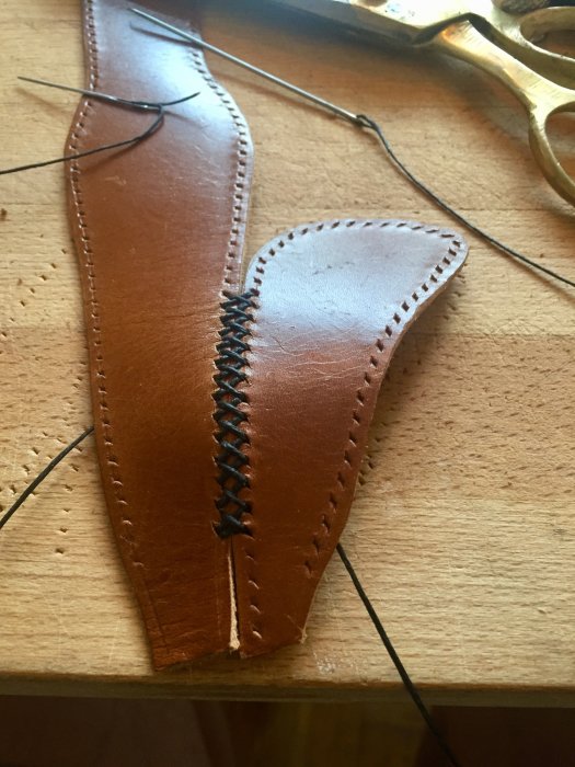 Handgjord läderhuva till växelspaksknoppen med synliga stygn och verktyg på träyta.