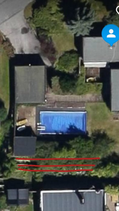 Flygfoto av en villa med en blå pool och en flerstegsmur som markerar tomtens terräng.