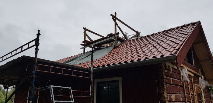 Renovering av tak med avlägsnat tegel och provisoriskt ställningsarbete på hus.