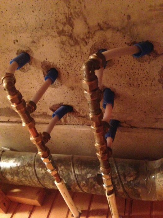 Rörinstallation med kopplingar och ventiler för vattenfördelning monterat i tak.