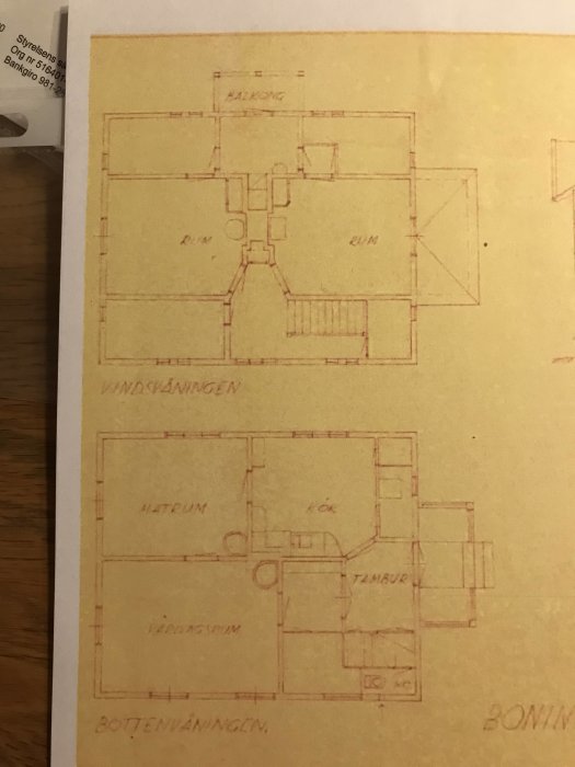 Arkitektritningar av ett tvåvåningshus, med markerat föreslaget badrum på övre våningen och kökets placering på bottenvåningen.