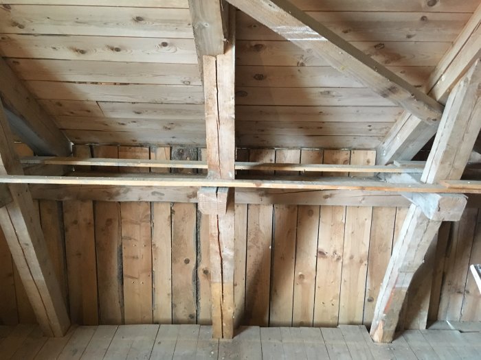 Träväggar och takbjälkar inuti en traditionell lada, potentiell isoleringsyta.