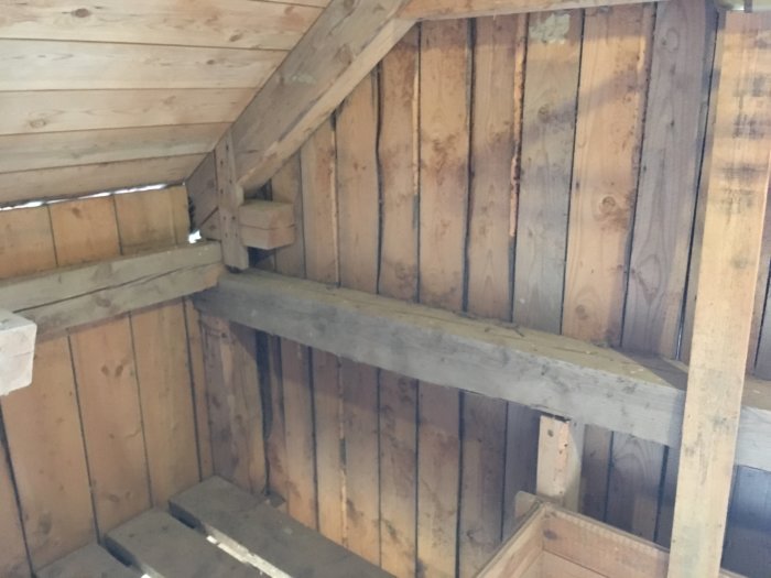 Träkonstruktion inuti en lada med synliga reglar och plankor, föreslagen för isolering.