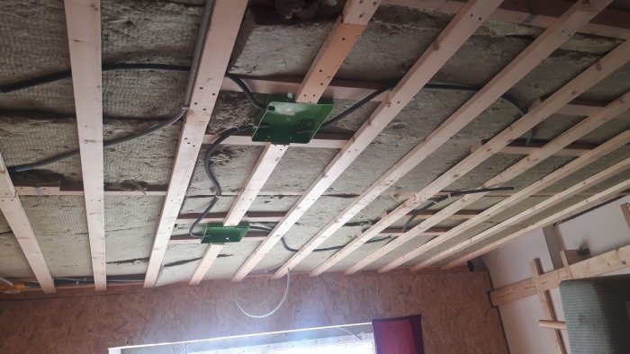 Tak med öppen isolering och elektriska dosor i framförberedelse för spotlightsinstallation.