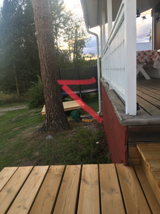 Altan med röd markerad linje som visar föreslagen utökning, stolpar och träplintar synliga.