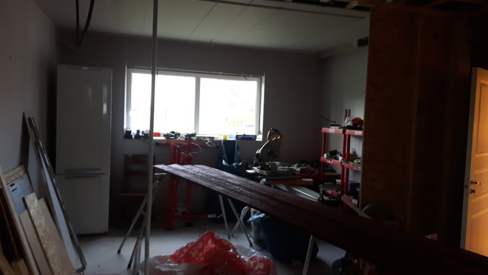 Renoveringsarbete i kök med gipstak och gipsväggar, verktyg och byggmaterial synliga.