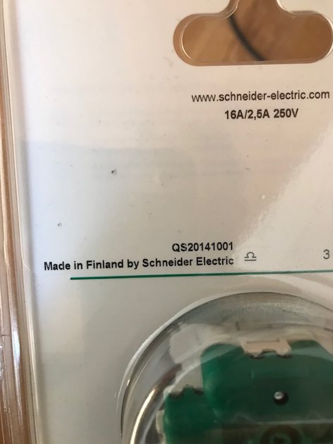 Ett förpackat Schneider Electric vägguttag med texten "Made in Finland".