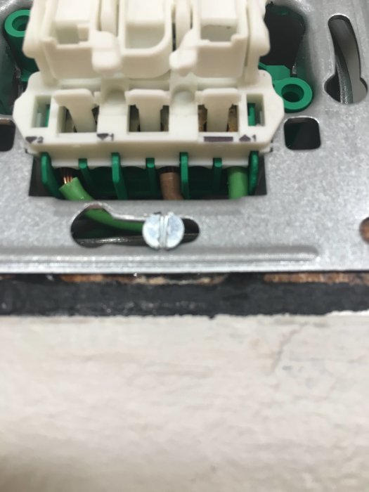 Närbild av en elektrisk komponent med synliga koppartrådar och anslutningar.
