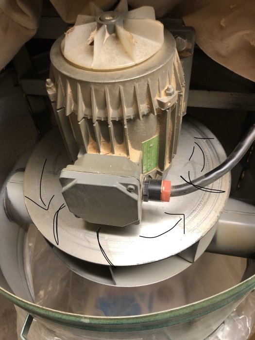 En dammsugarmotor med märkta pilar som visar propellerbladens böjningsriktning och rotation.